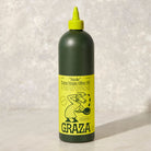 Graza Sizzle Olive Oil on a grey surface