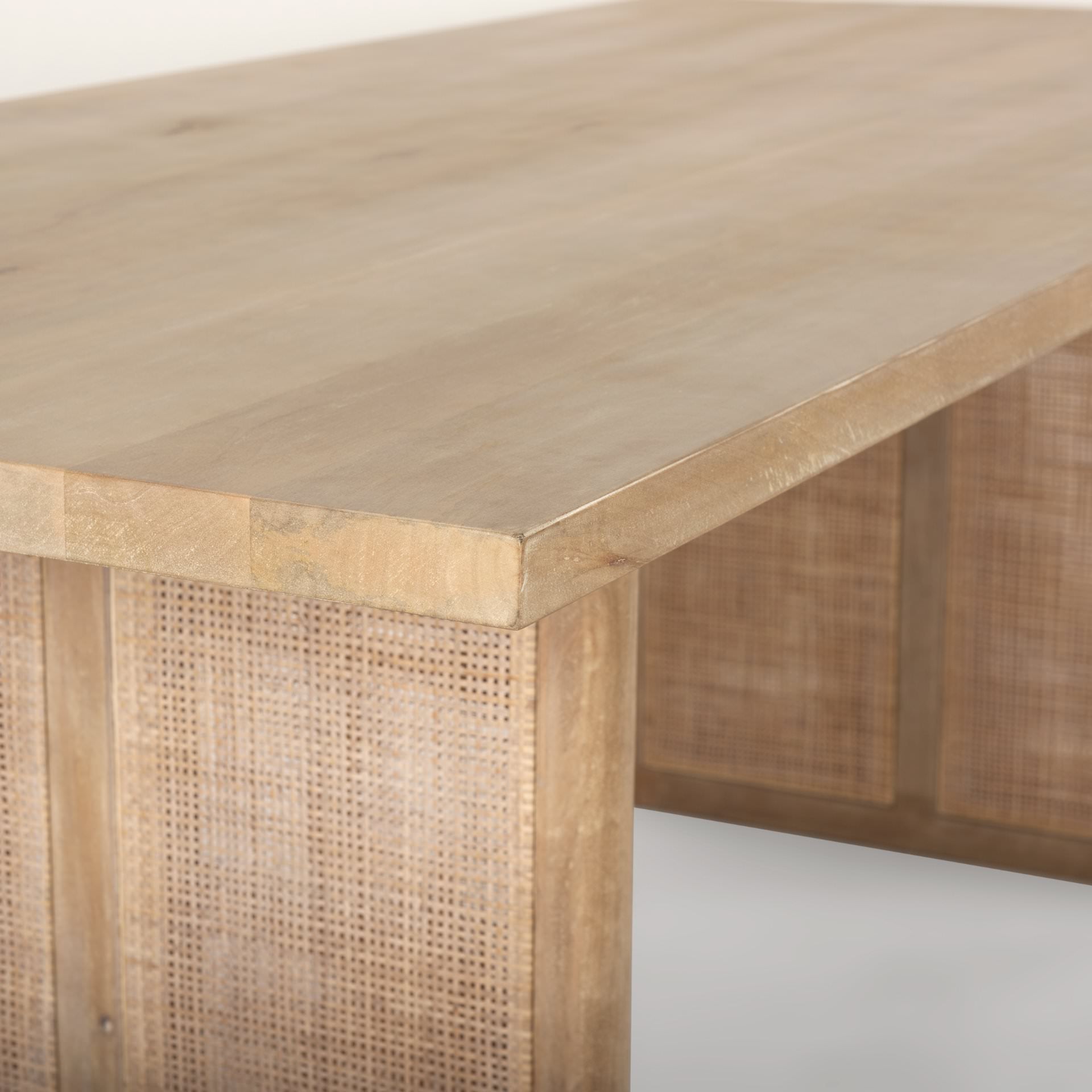 Close up of Grier 84 inch long Light Brown Wood with Cane Dining Table on a white background