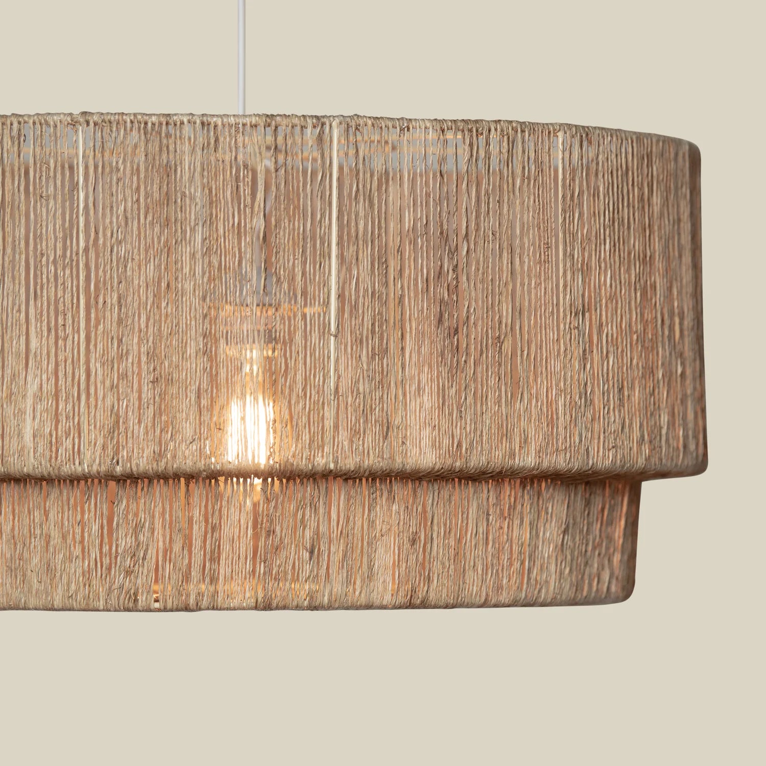 Close up of Cocktail 2 Tier Jute Pendant on a beige background at Addison West