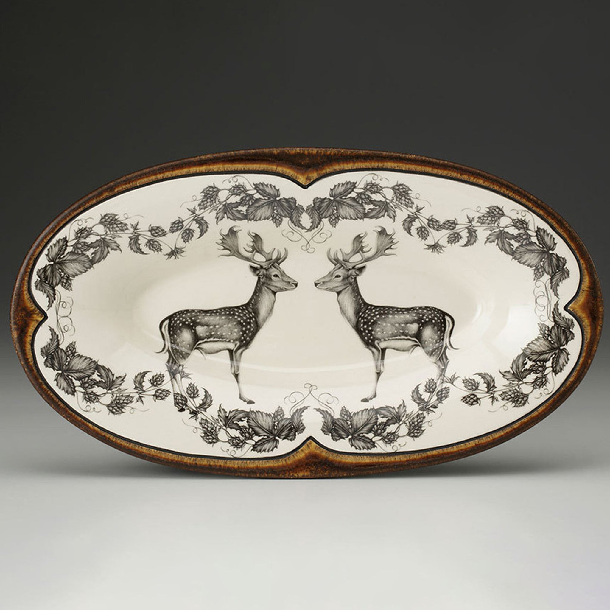 Decorative platter with deer design on a plain background