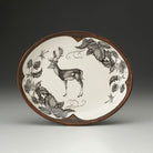 Decorative plate with a deer and leaf design on a beige background