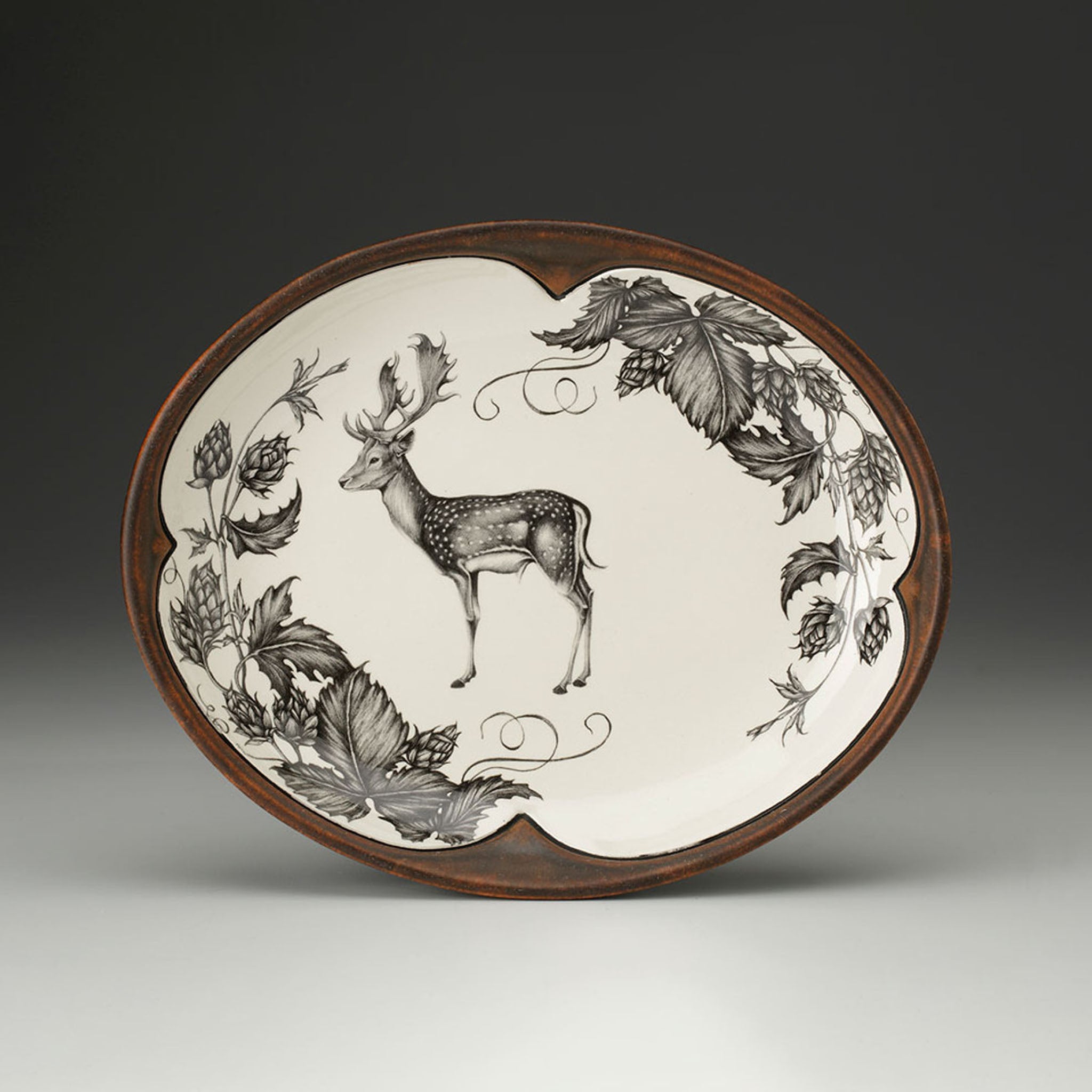 Decorative plate with a deer and leaf design on a beige background