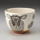Ceramic bowl with a black and white sheep illustration on a beige background