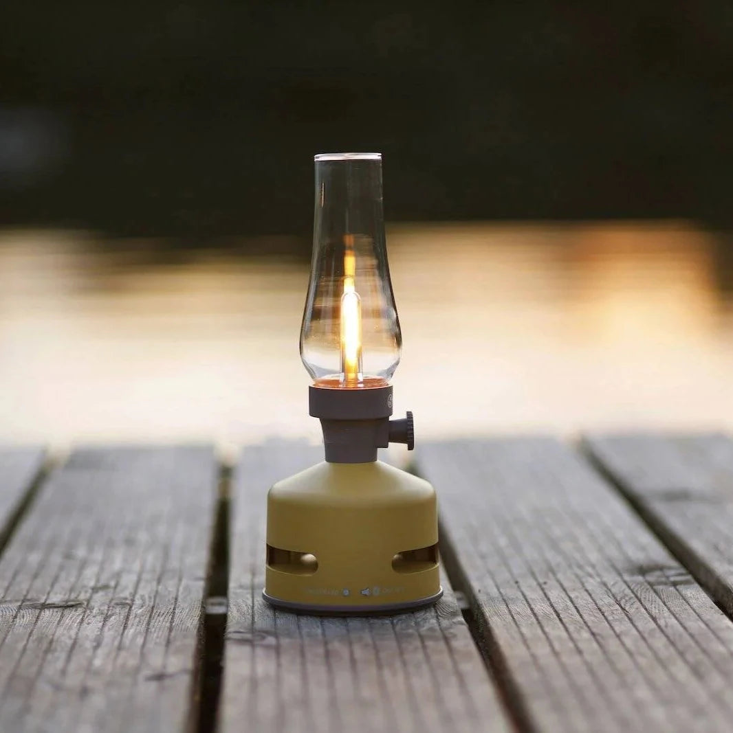 Light and Sound LED Lantern with Speaker in Mustard Yellow on a dock with a lake in the background at Addison West