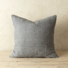 Lina Linen 20" Square Pillow in Grey on a wood floor and in front of a beige wall at Addison West