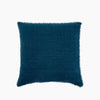 Square blue linen pillow with frayed edges on a white background