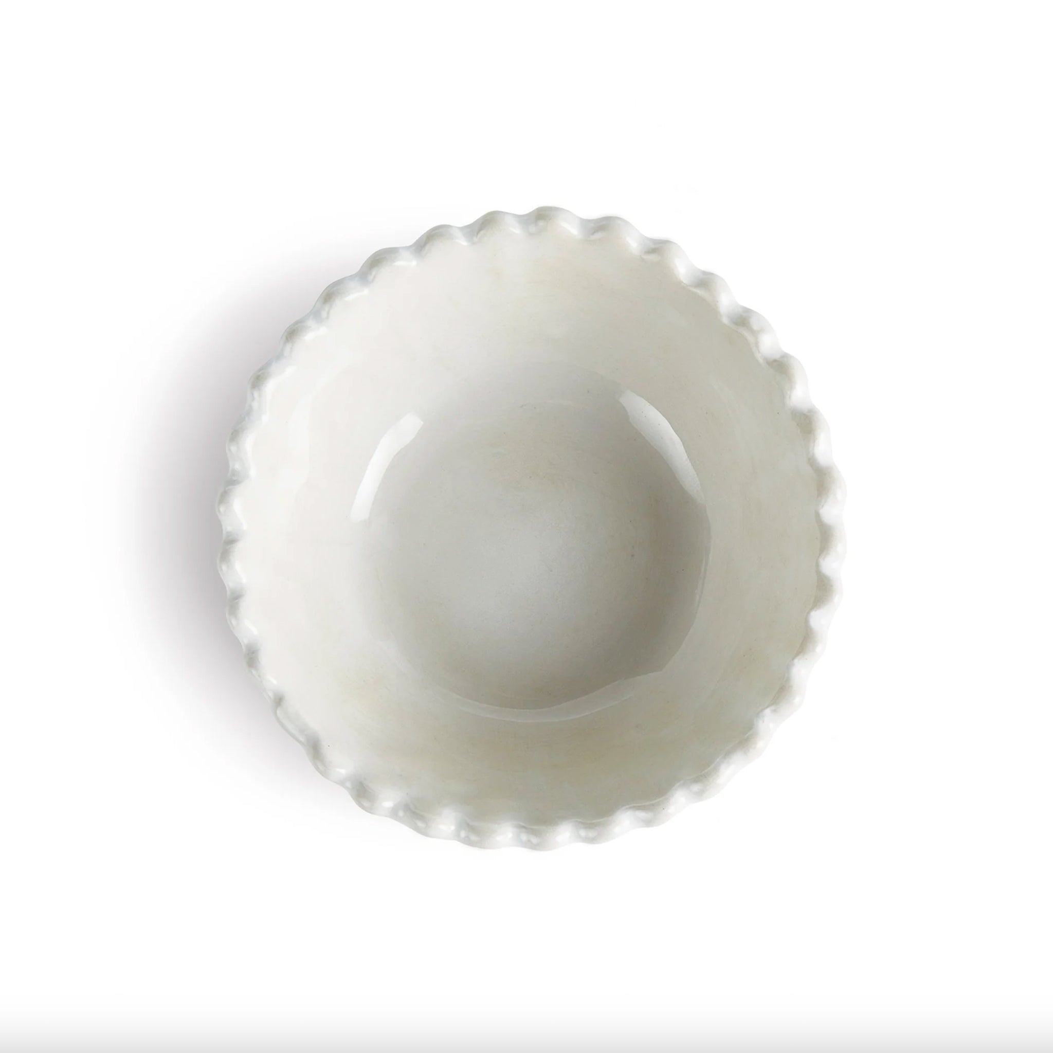 White ceramic bowl with scalloped edge on a white background