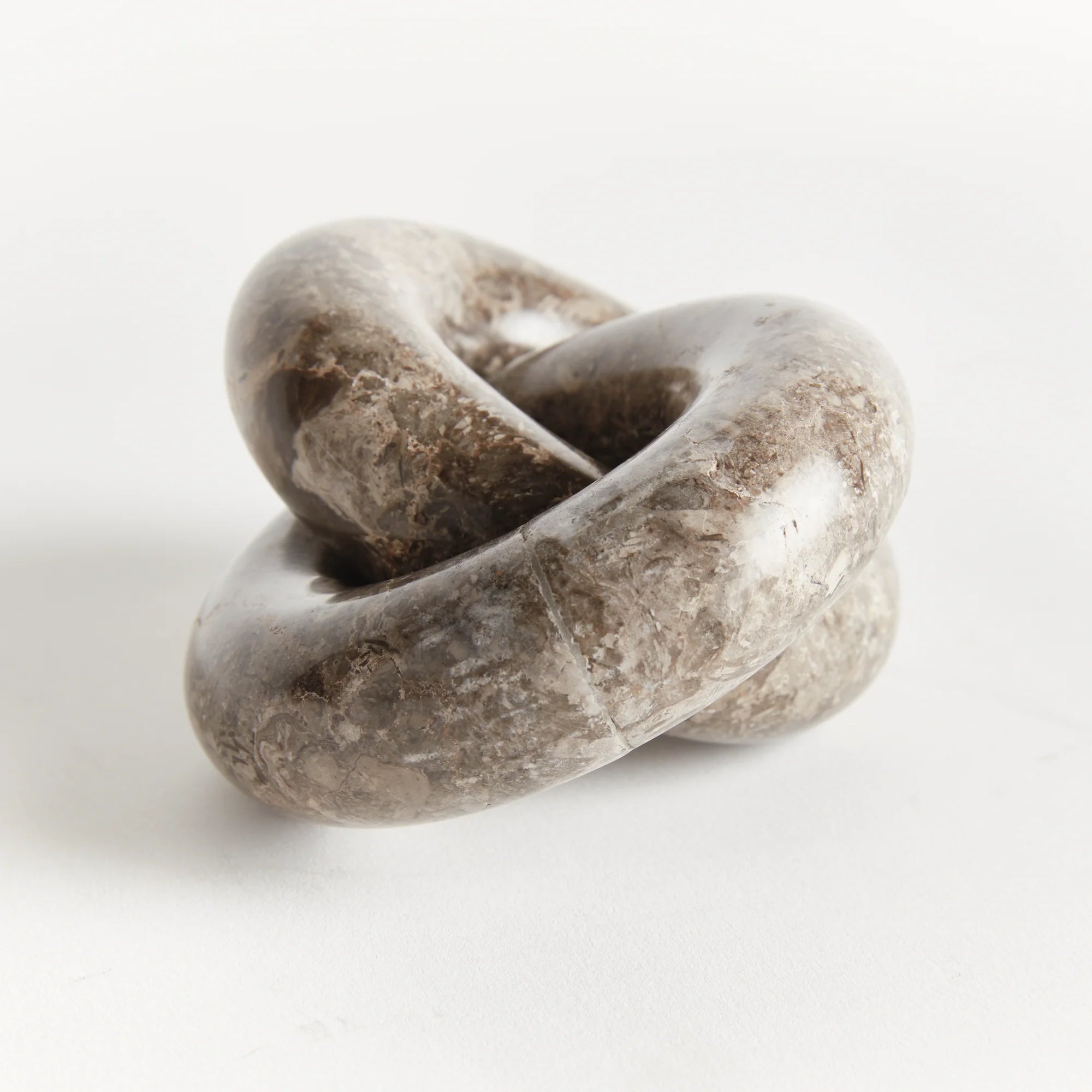 Marble Links Sculpture on white background at Addison West.