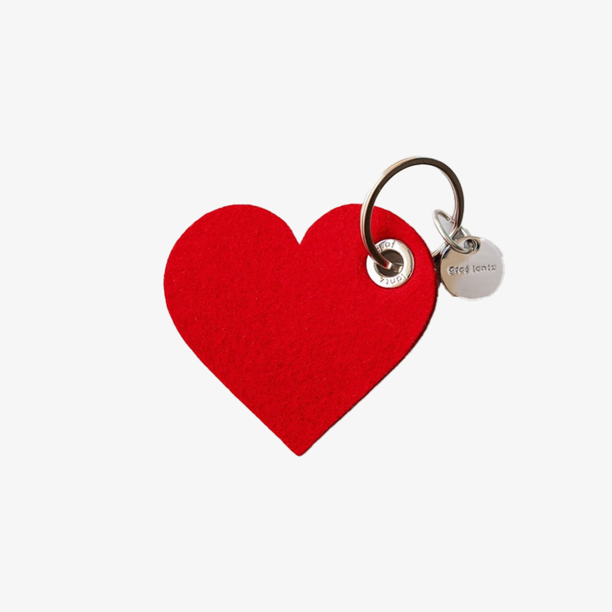 Red heart-shaped keychain with a tag on a white background