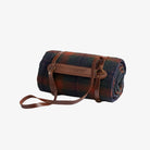 Roll-up plaid blanket with leather strap on a white background