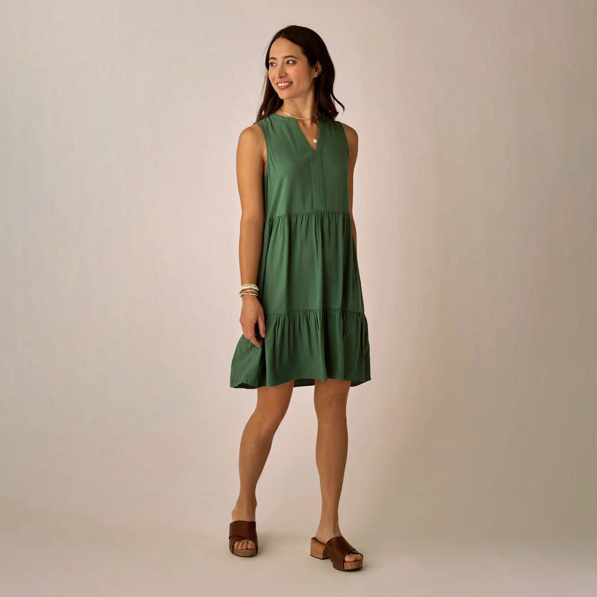 Nellie Dress in Dark Grass shown on model on plain background.