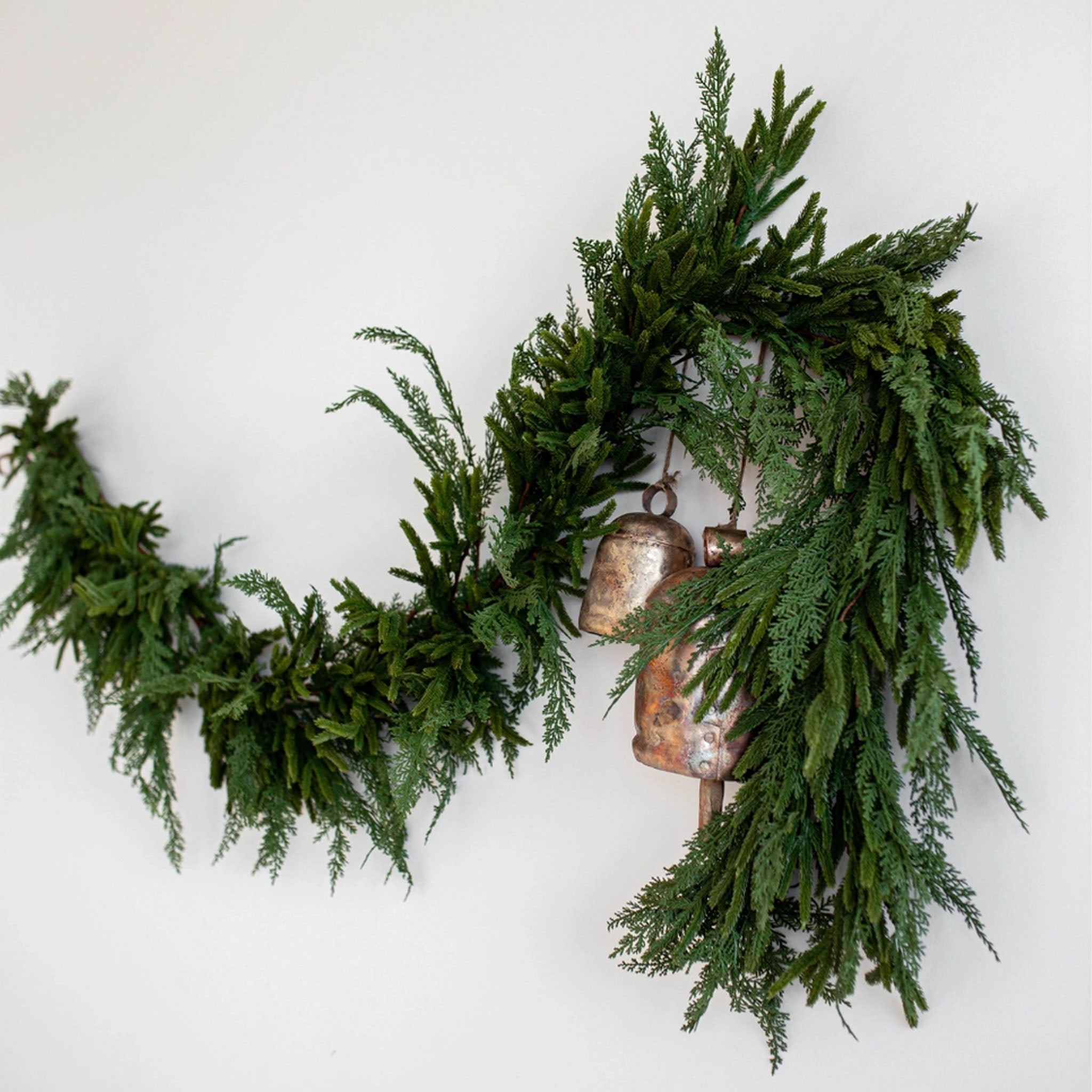 Norfolk & Cypress Mix Real Touch Faux Garland, 9ft on a white wall at Addison West
