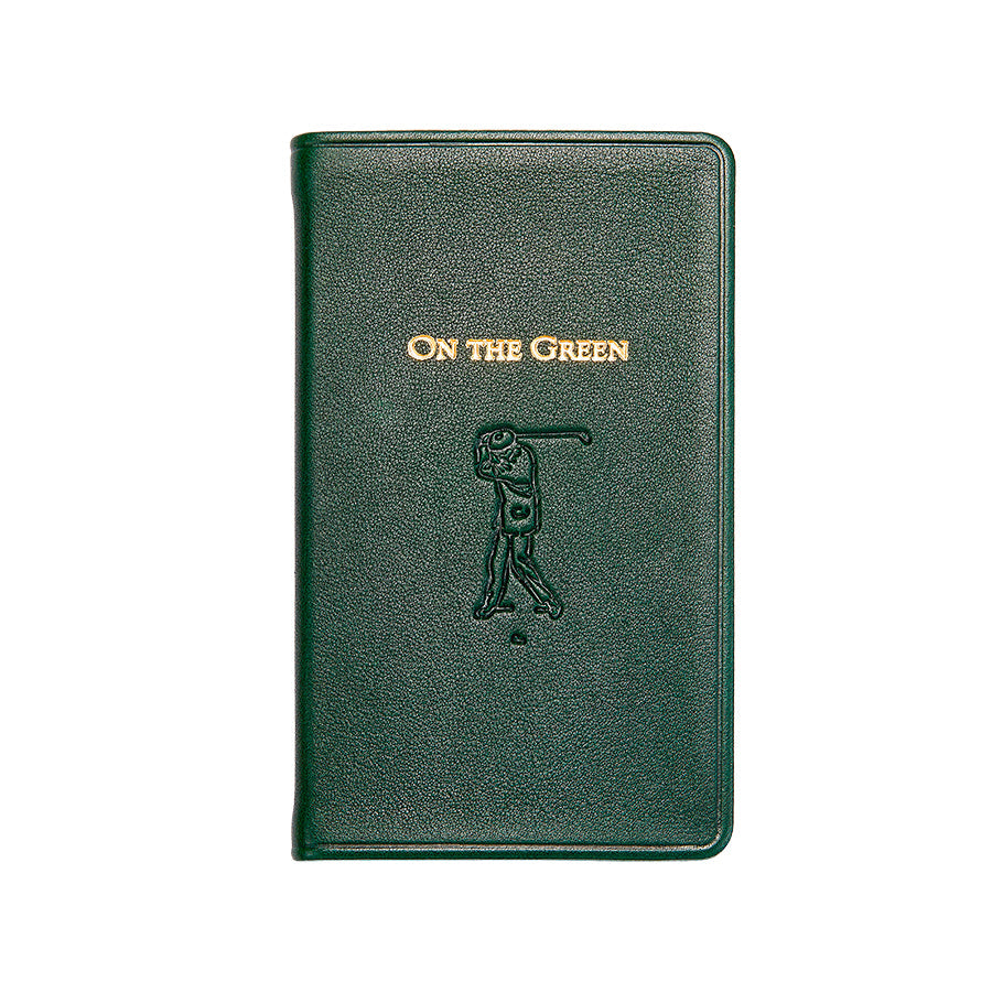 Green notebook with 'On The Green' and golf club design on a white background