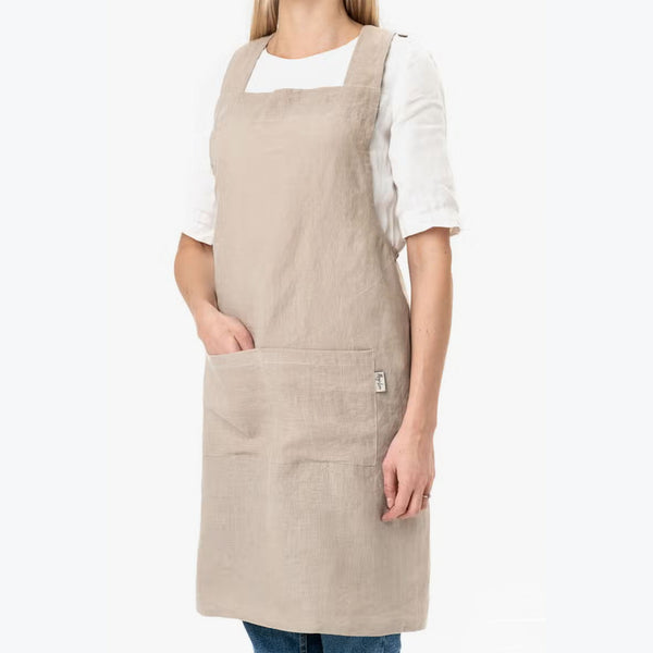 Model wearing Cross-Back Linen Apron in Natural Linen on a white backrgound