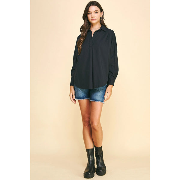 Brunet model wearing jean shorts and black boots and black drop shoulder long sleeve shirt
