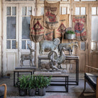 Collection of weather vases on tables in front of rustic wood doors