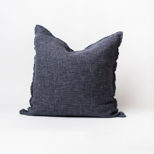 Navy blue square linen pillow with slightly frayed edges on a white background