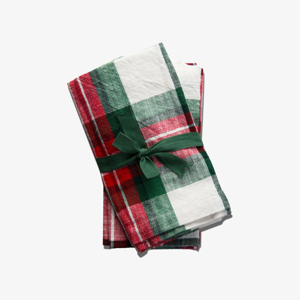 Set of four plaid holiday green, white and red napkins on a white backrgound