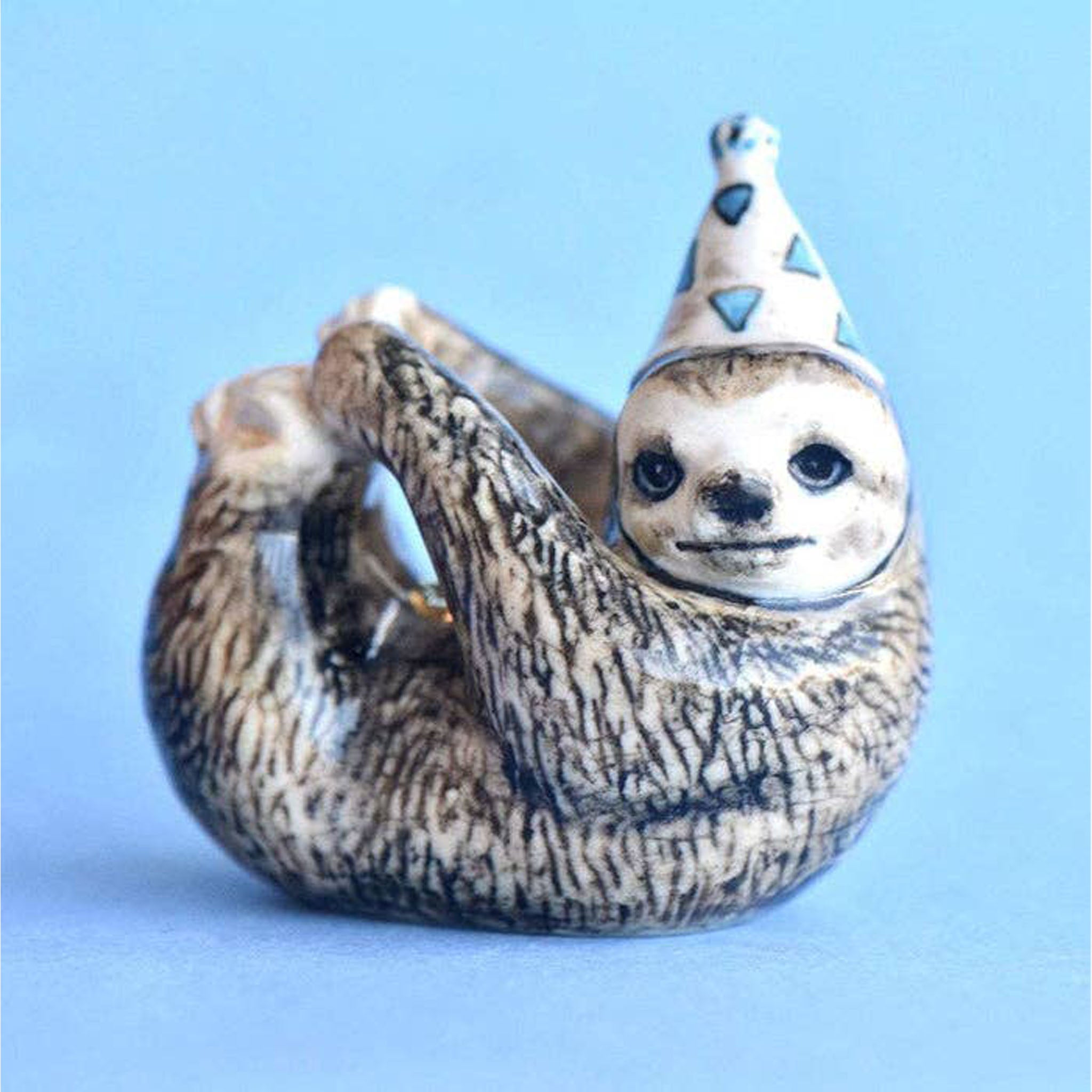 Sloth Cake Topper with blue and white birthday hat on a blue background
