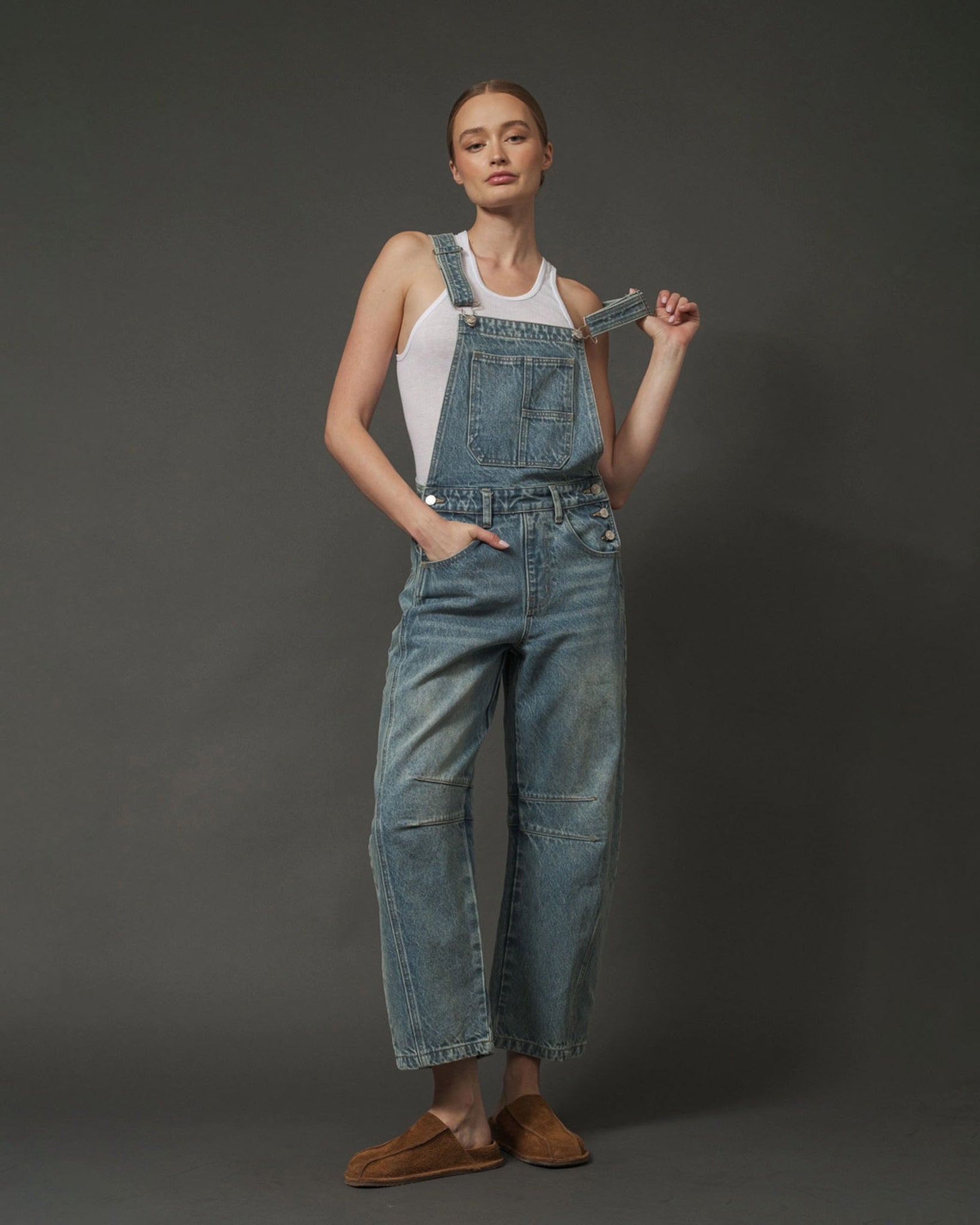 Woman wearing Aaron & Amber Relaxed Fit Overalls in Denim on a dark background