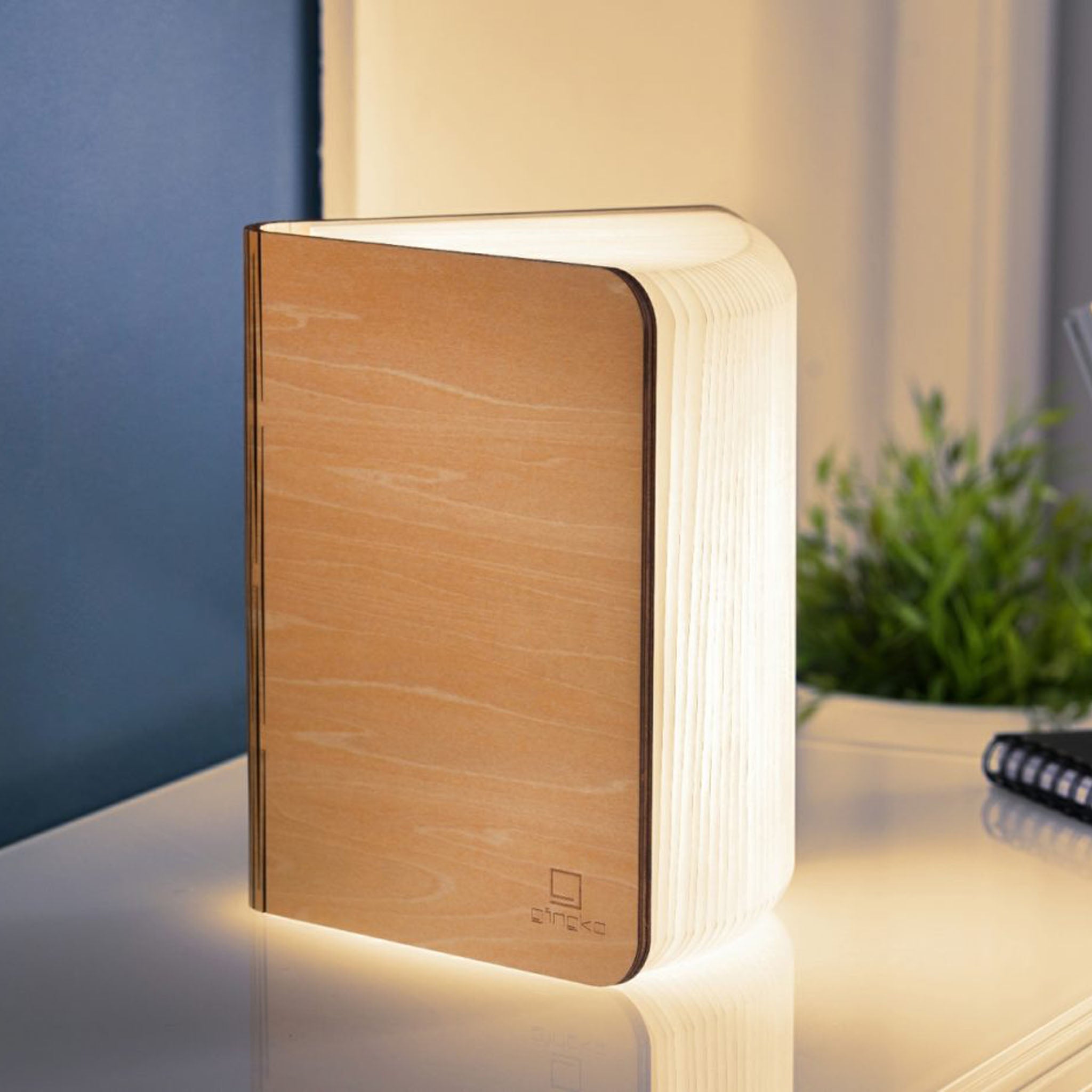 Wooden book-shaped night light on a surface with a blurred background