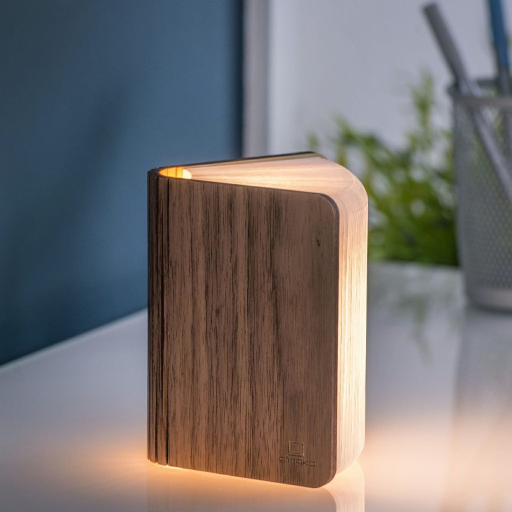 Wooden book lamp with warm glow on a surface with a blurred background