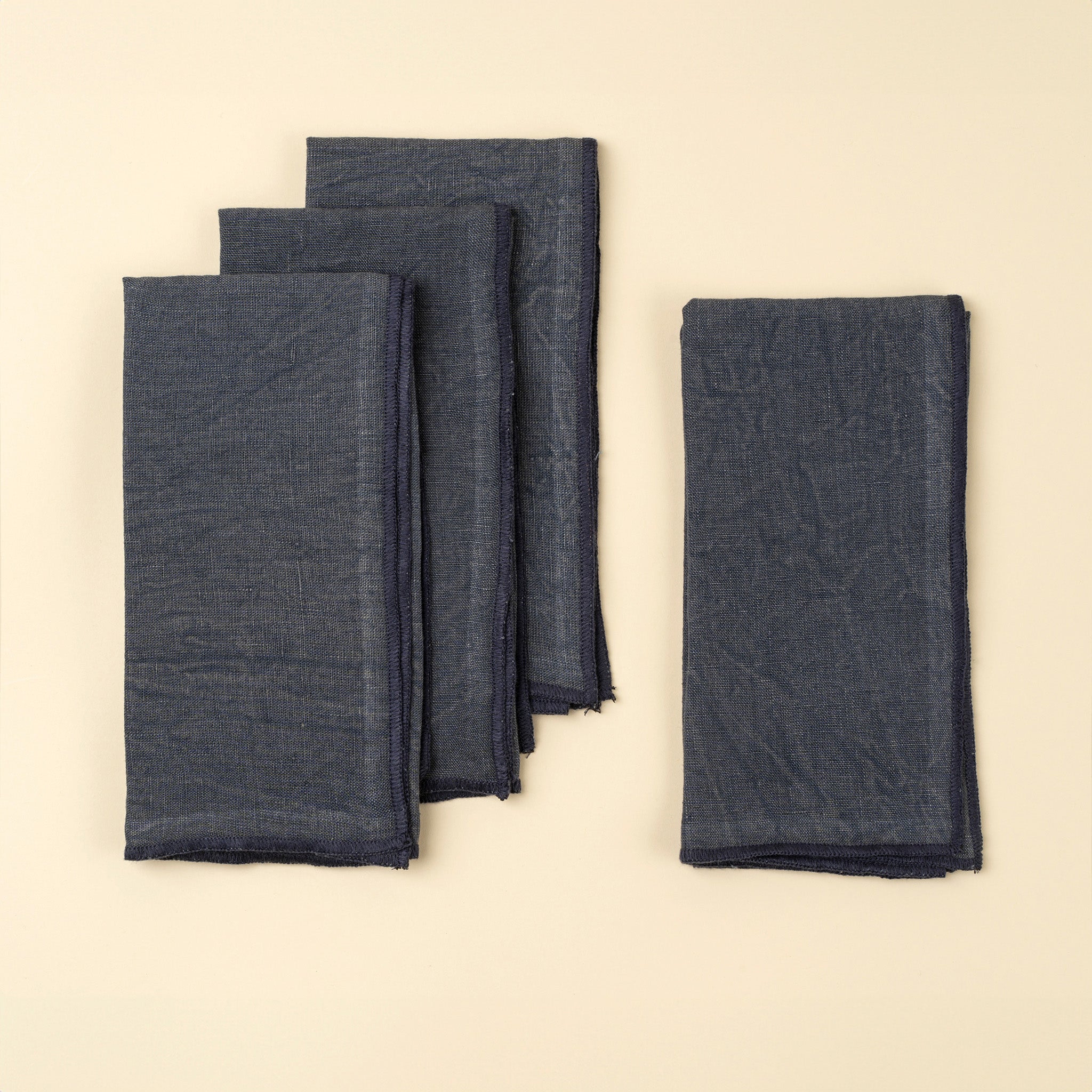 Stonewash Navy Linen Napkins, Set of 4 on a beige background at Addison West