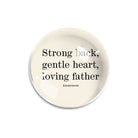'Strong back, gentle heart' quotation on round glass paperweight on a white background