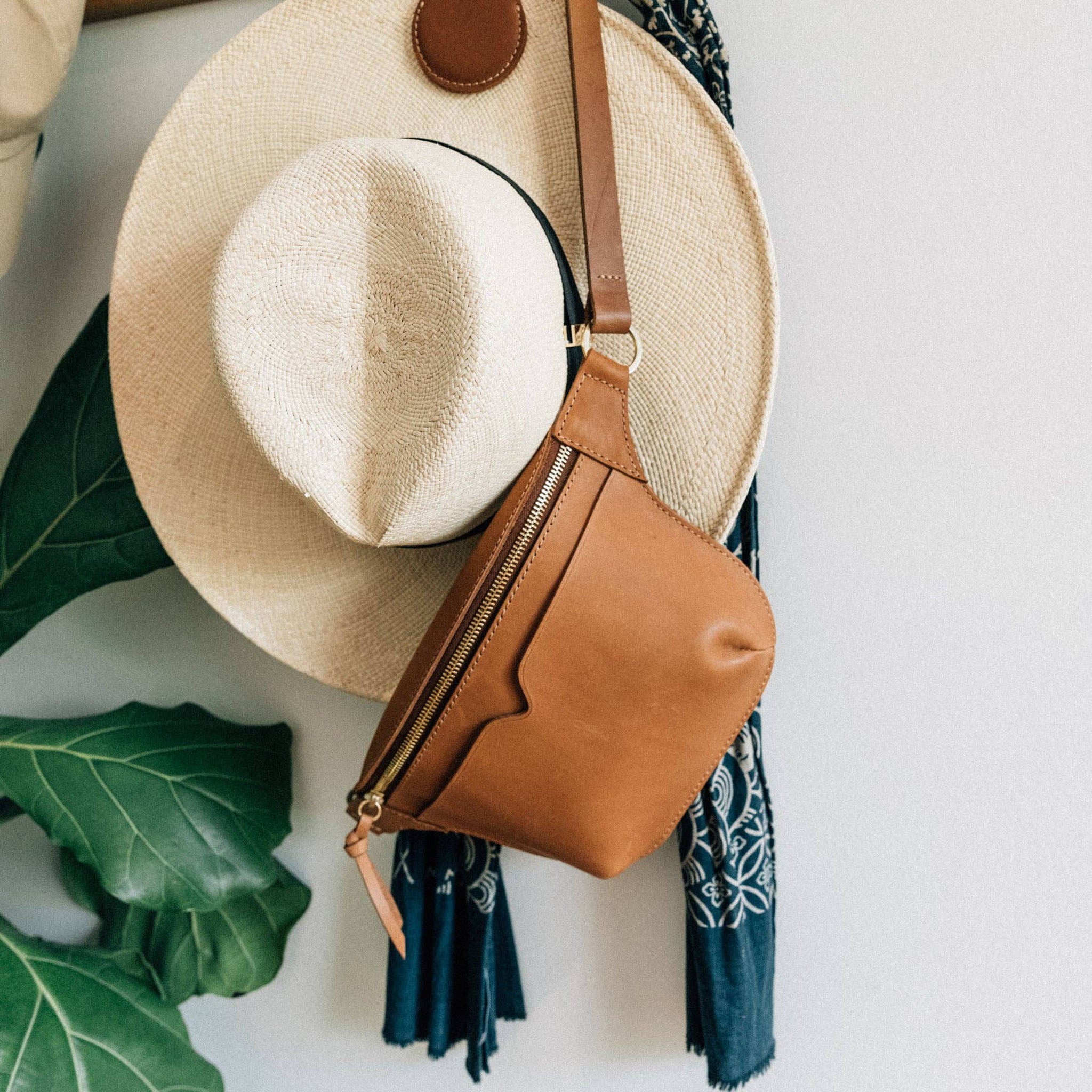 The Leather Sling Bag on a wall background at Addison West