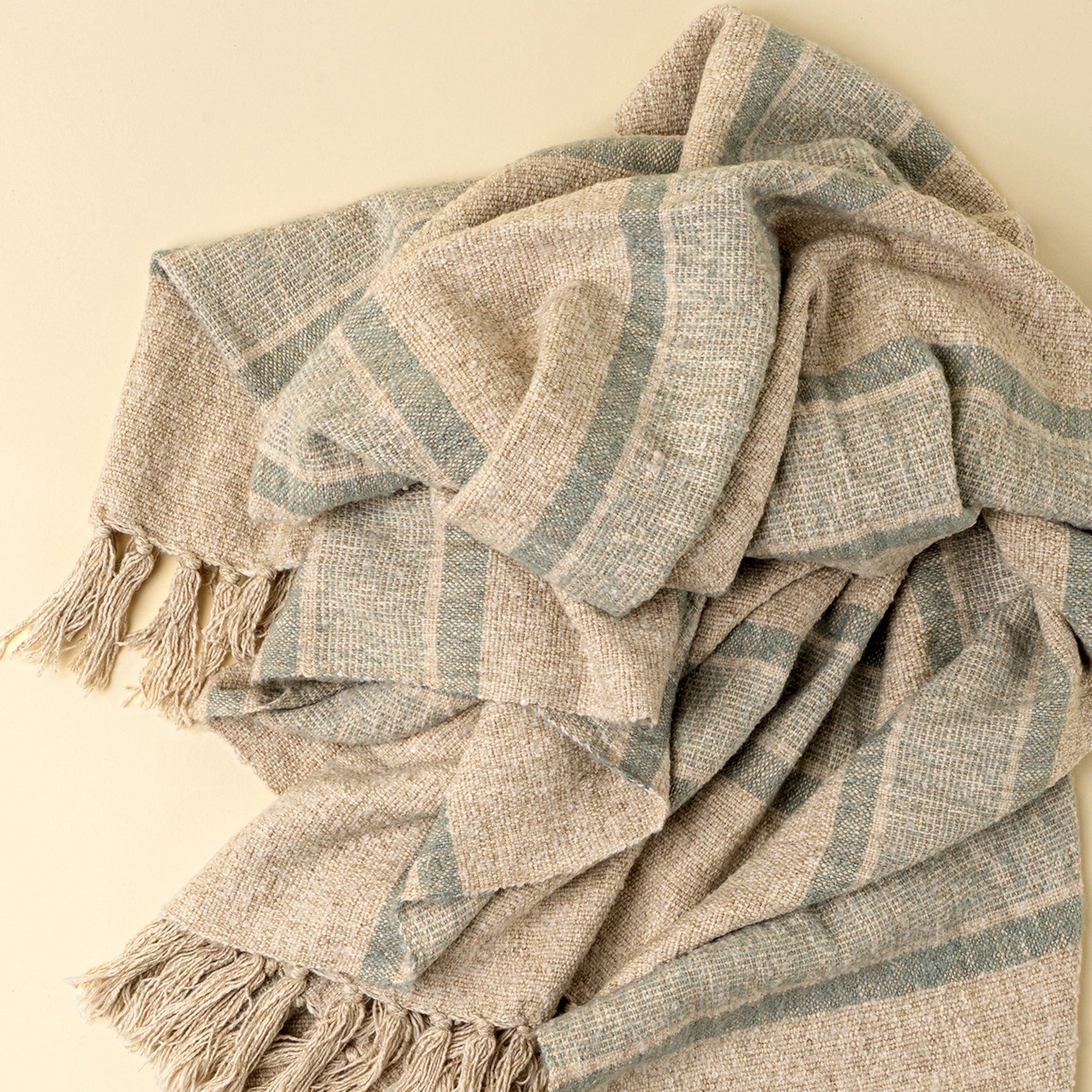Close up of Tulum Striped Throw in Blue on a beige background at Addison West