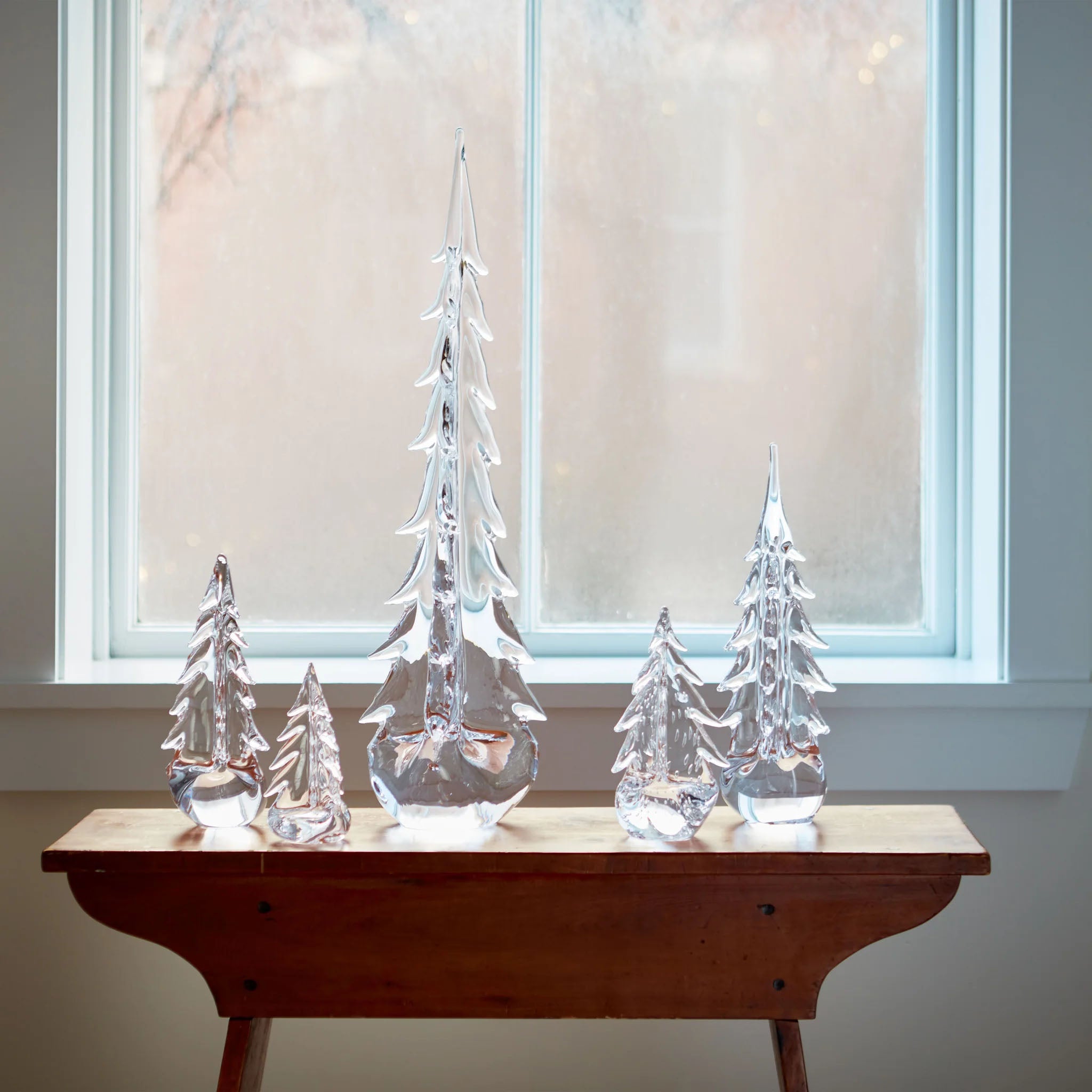 Vermont Evergreen Glass Trees on a table in front of a window at Addison West