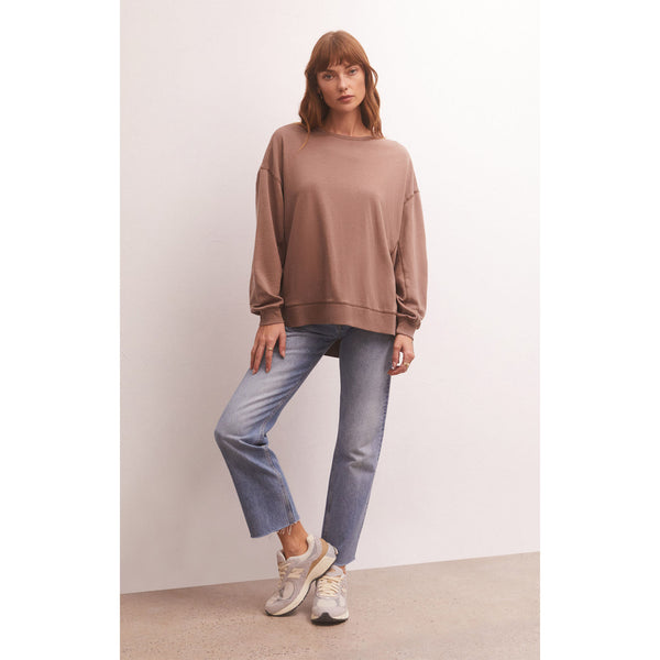 Model wearing Z Supply Modern Weekender in Milk Shake with jeans and sneakers in front of a white wall