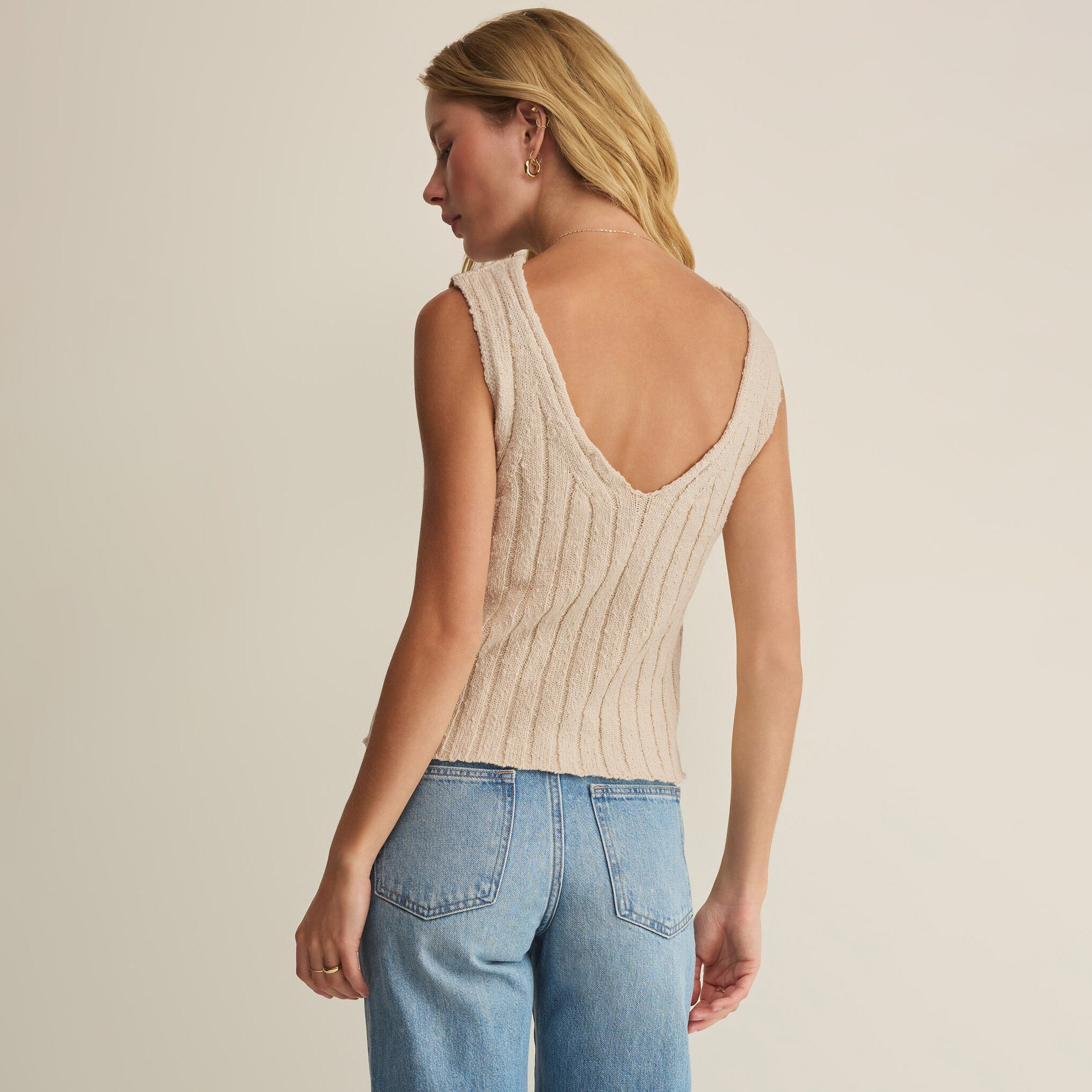 Woman wearing Z Supply Acadia Sweater Tank in Island Coconut on plain background at Addison West.