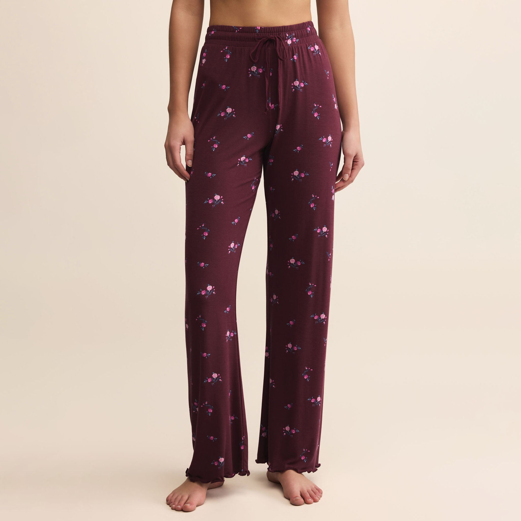 Maroon pajama pants with a subtle pattern on a beige background