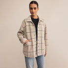 Woman wearing Z supply  beige checkered coat on a beige background