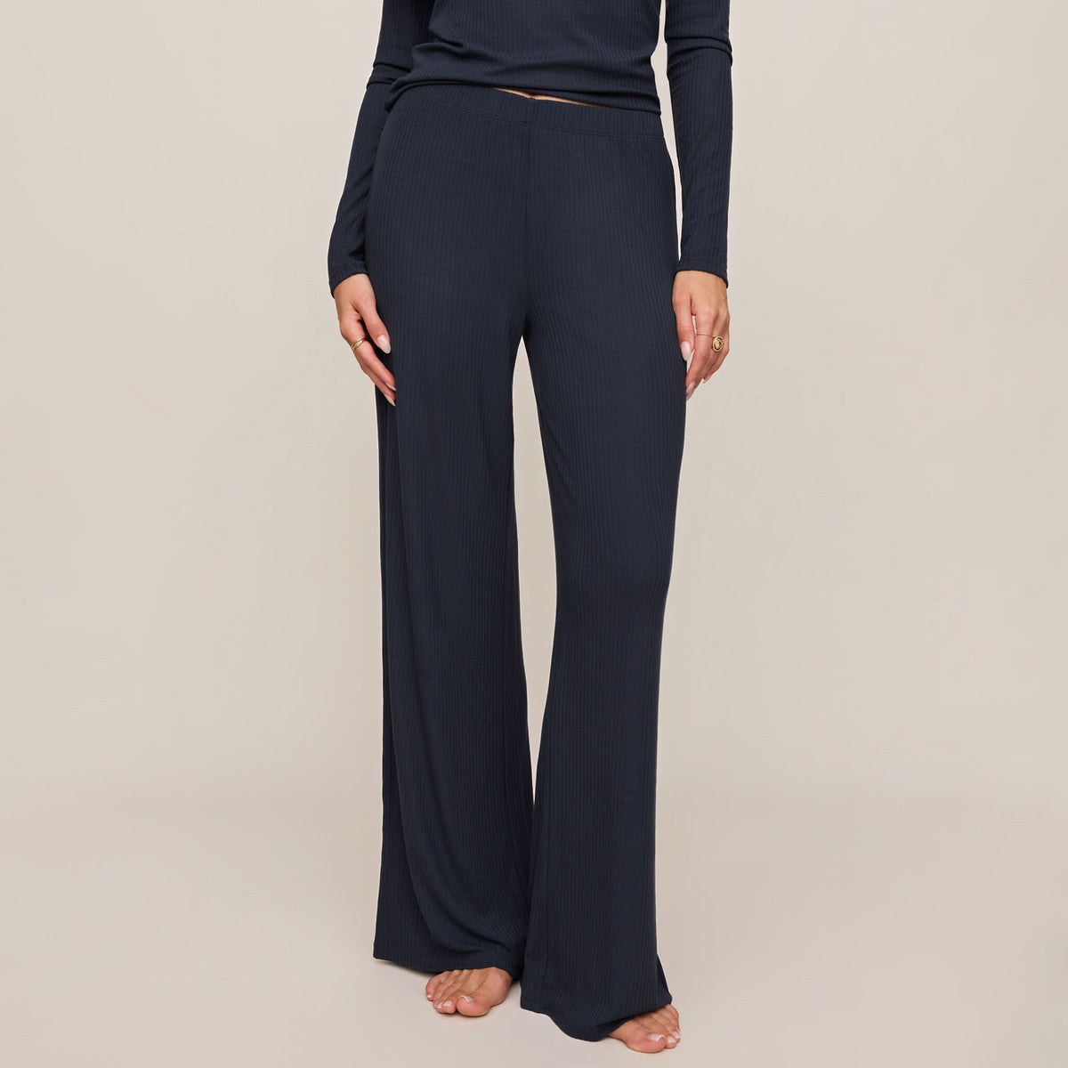 Navy blue pants worn by a person on a beige background