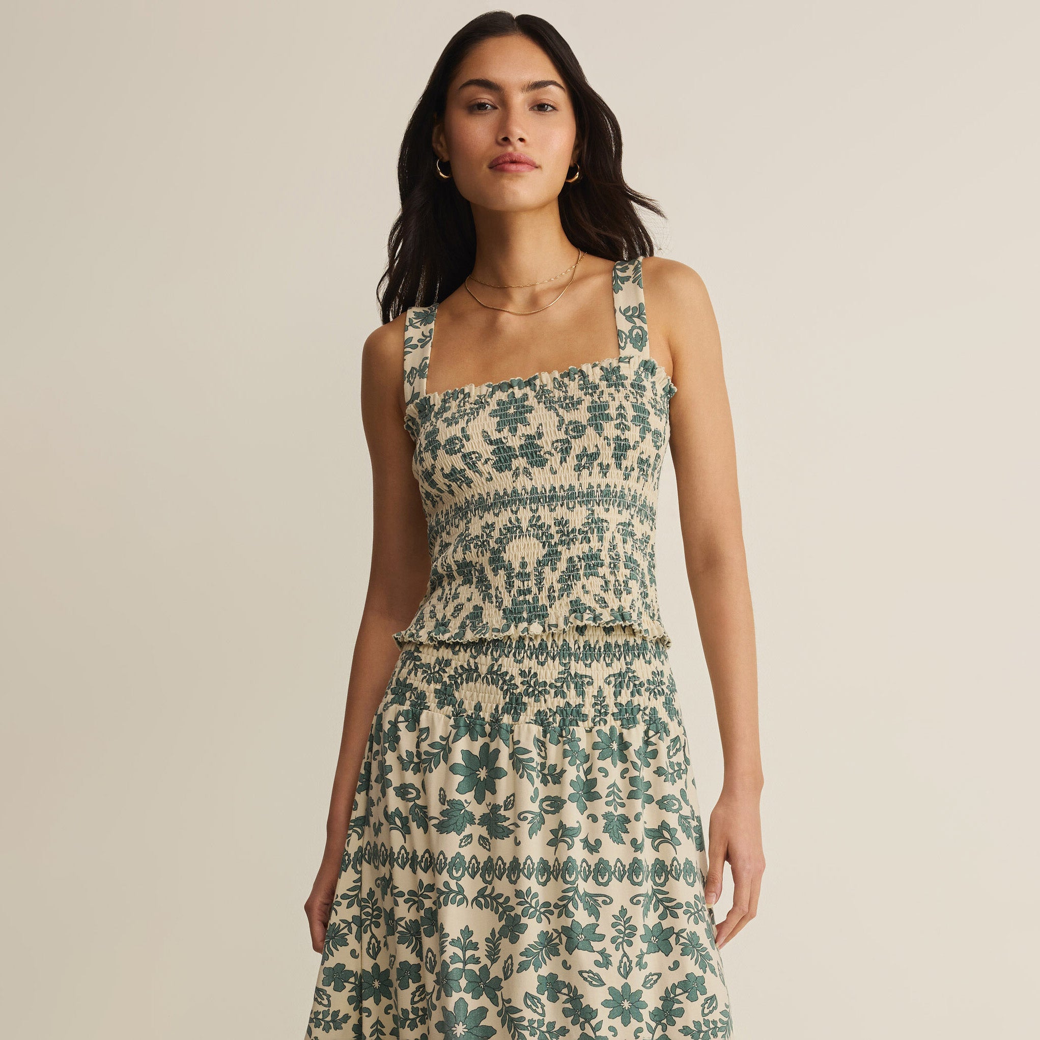 Woman wearing Z Supply Leya Tera Paisley Smocked Top in Everglade on plain background at Addison West.