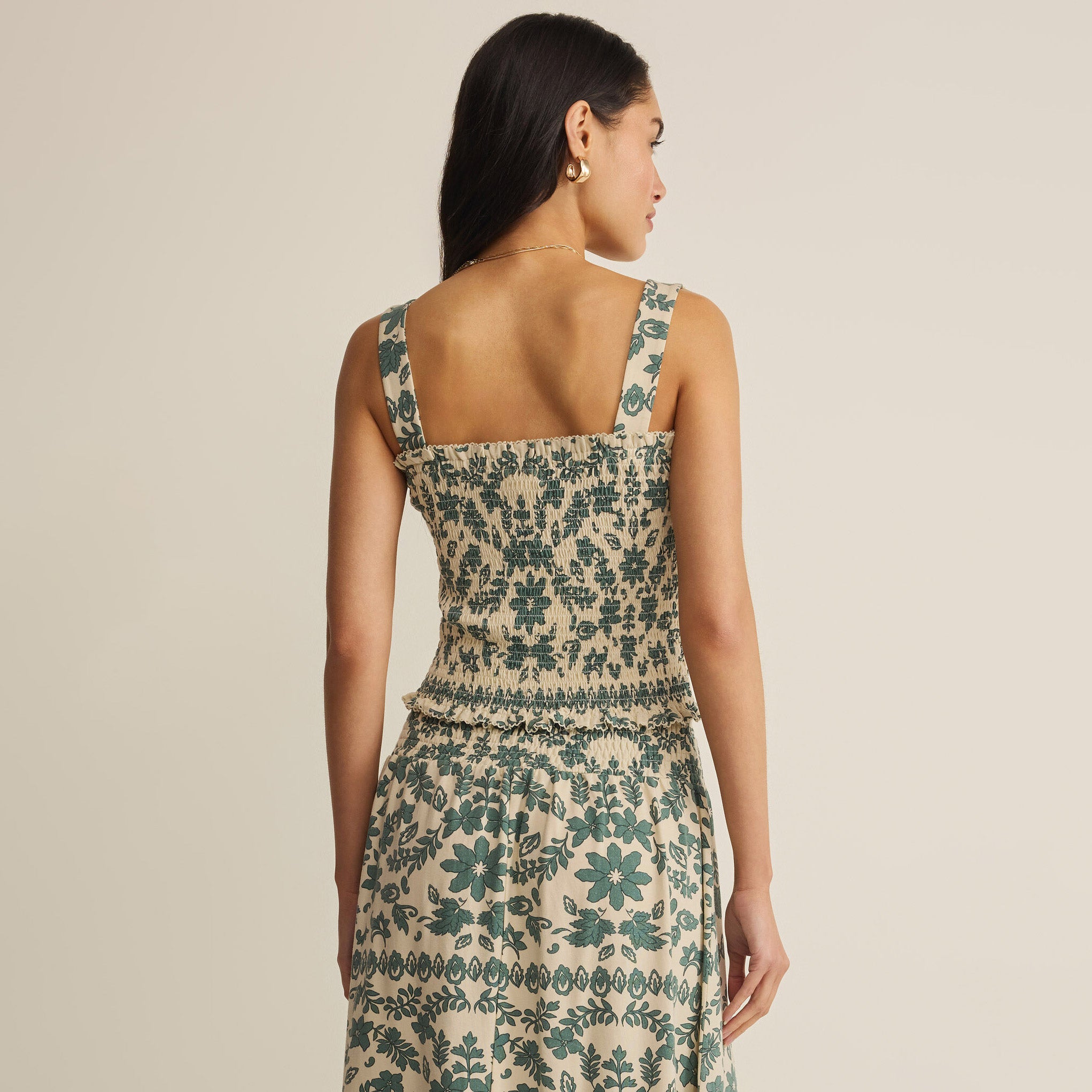 Woman wearing Z Supply Leya Tera Paisley Smocked Top in Everglade on plain background at Addison West.