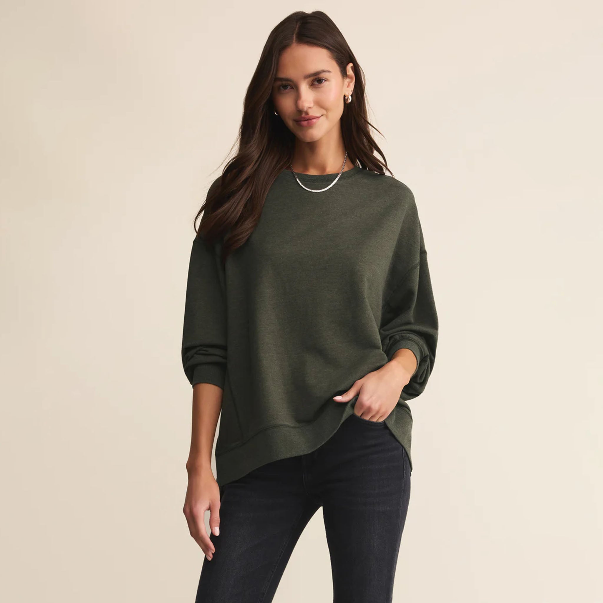 Woman wearing a green sweater against a beige background