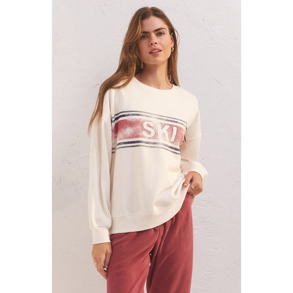 Model wearing red sweatpants and Z Supply Oversized Ski Sweatshirt in Bone in front of a white background