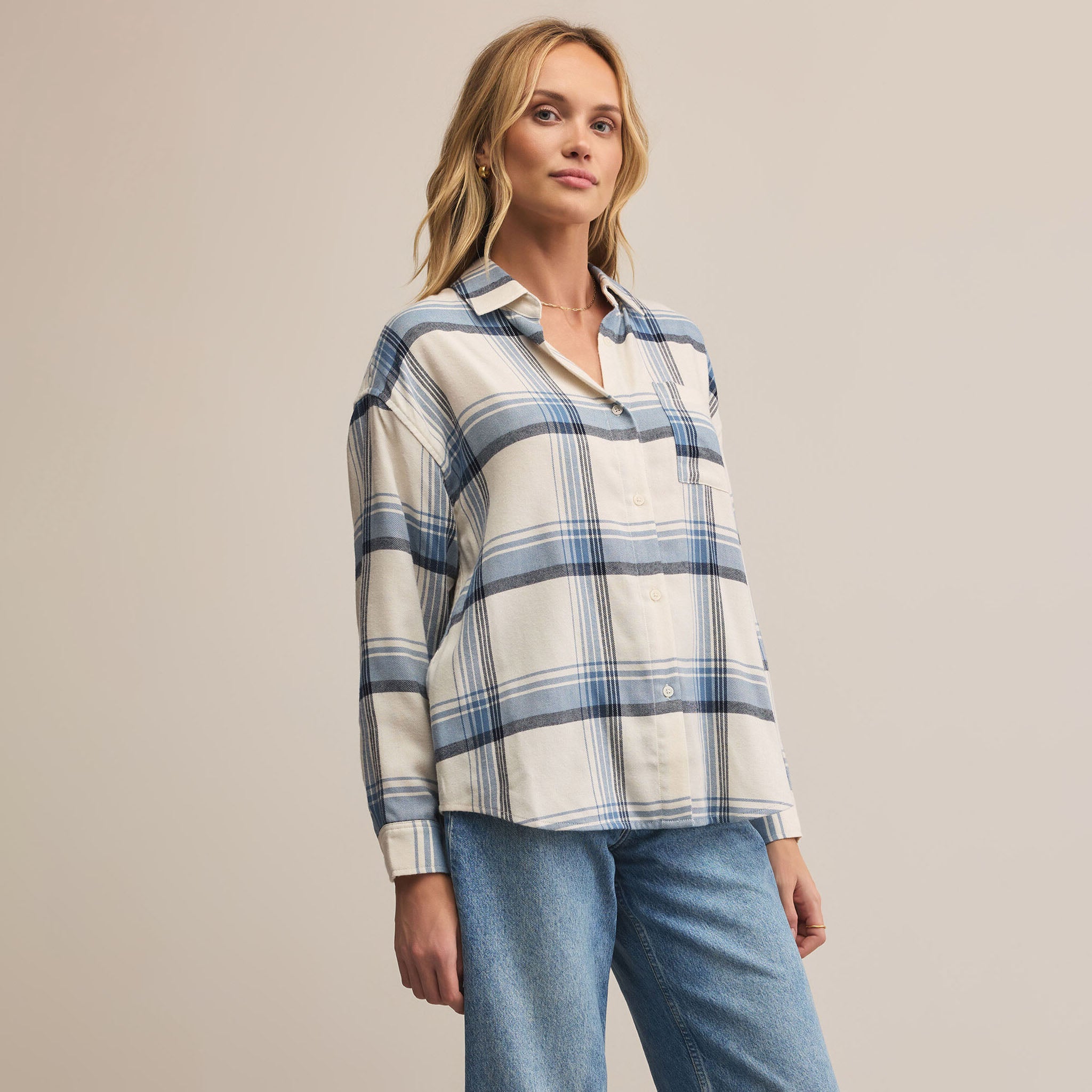 Z Supply River Plaid Button Up in Vintage Indigo on a beige background at Addison West