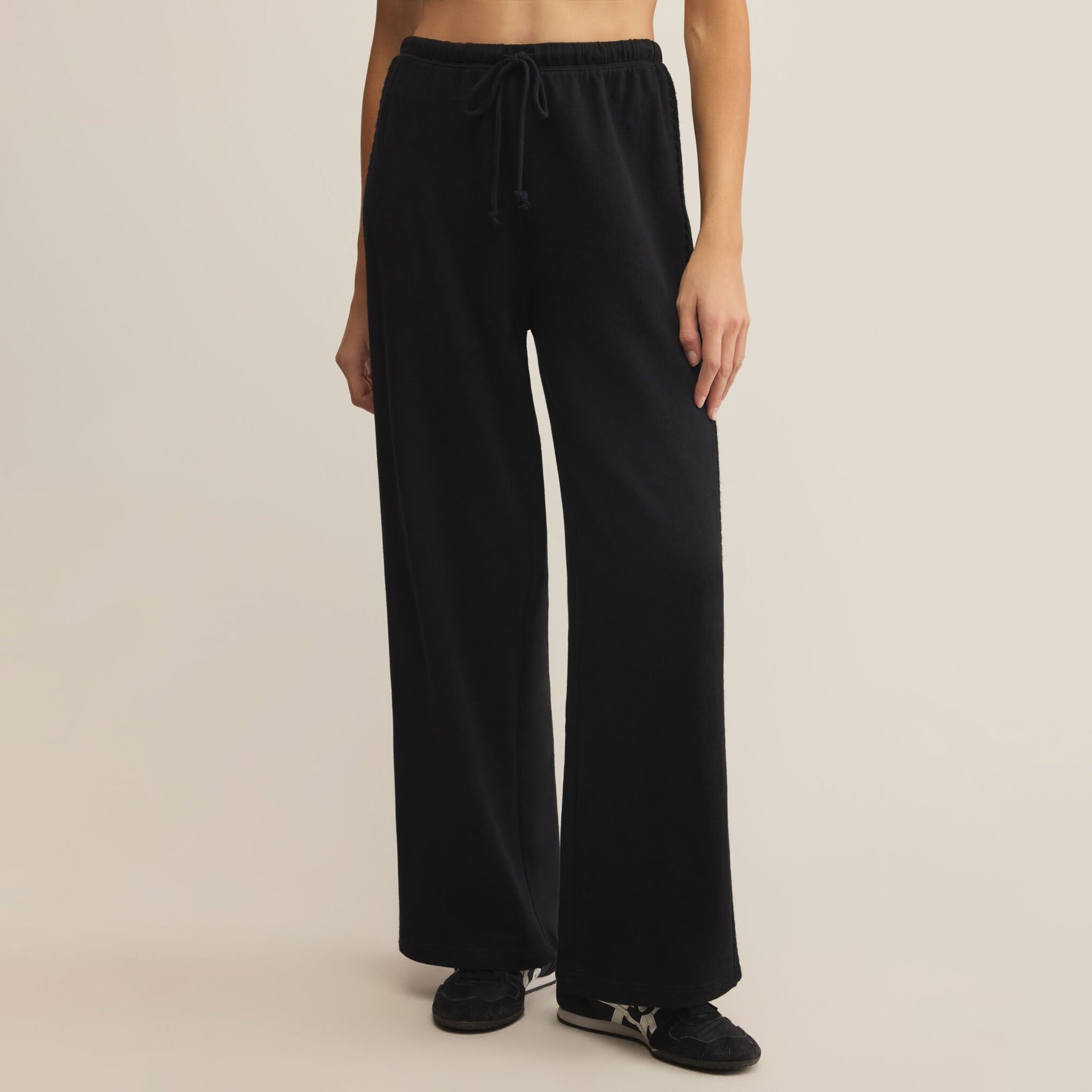 Z Supply Take All Sweatpant in Black worn by a person on a beige background