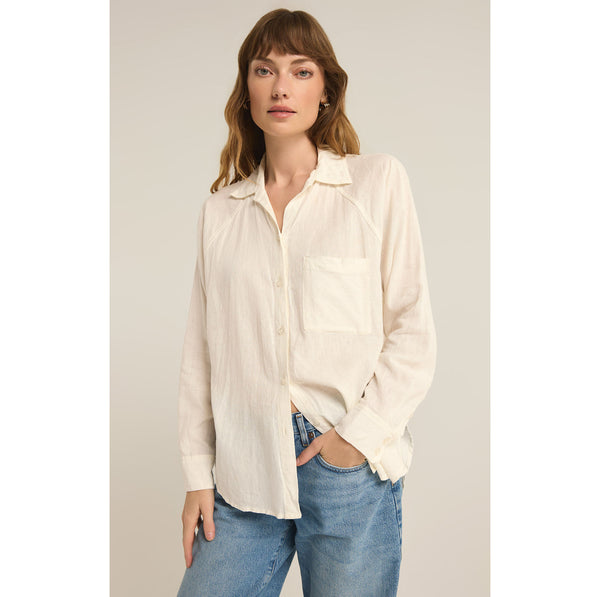 Model wearing Z Supply The Perfect Linen Top in White with jeans in front of a neutral background
