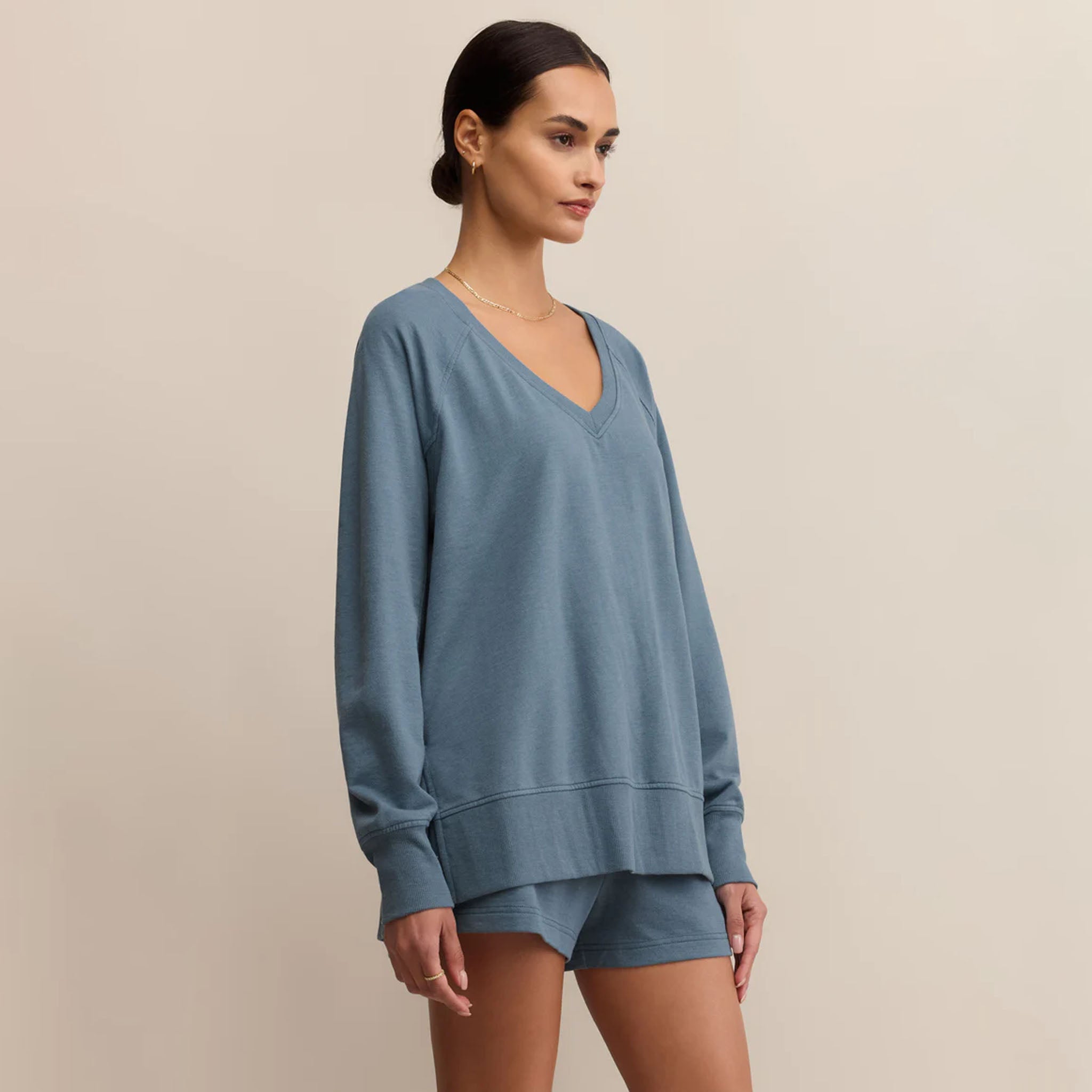 Woman wearing Z Supply Weekender V Neck in Boathouse on a beige background