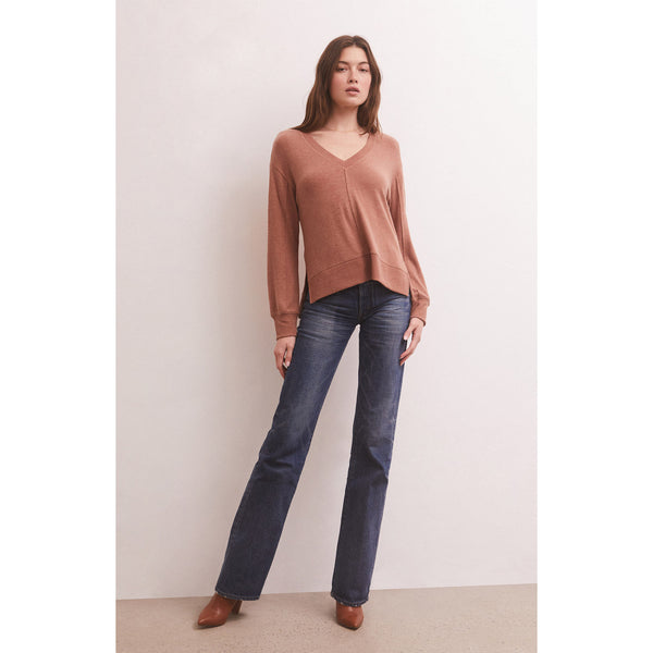 Model wearing jeans and Z Supply Wilder Cloud V-Neck Long Sleeve Top in Penny in front of a neutral wall
