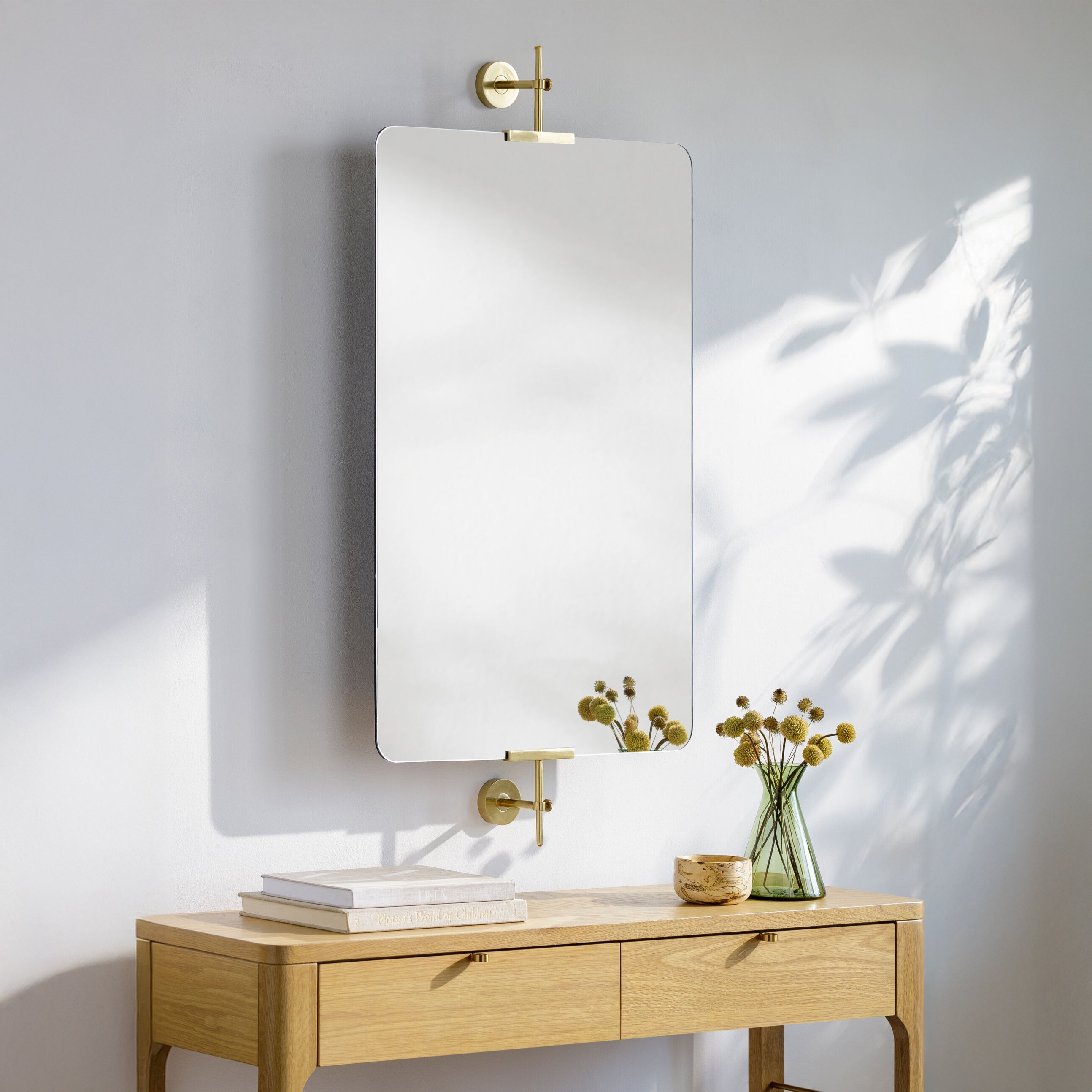 Anastasya Accent Mirror on a white wall above a table at Addison West