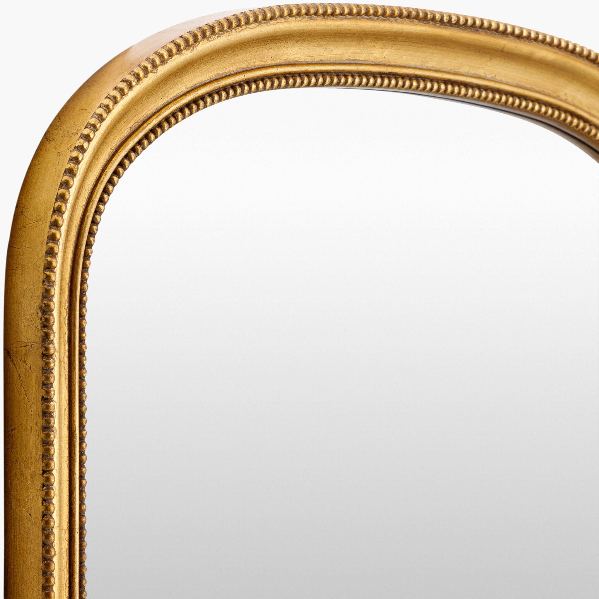 Close up of Nalanda Mantel Mirror in Antiqued Gold on a white background at Addison West