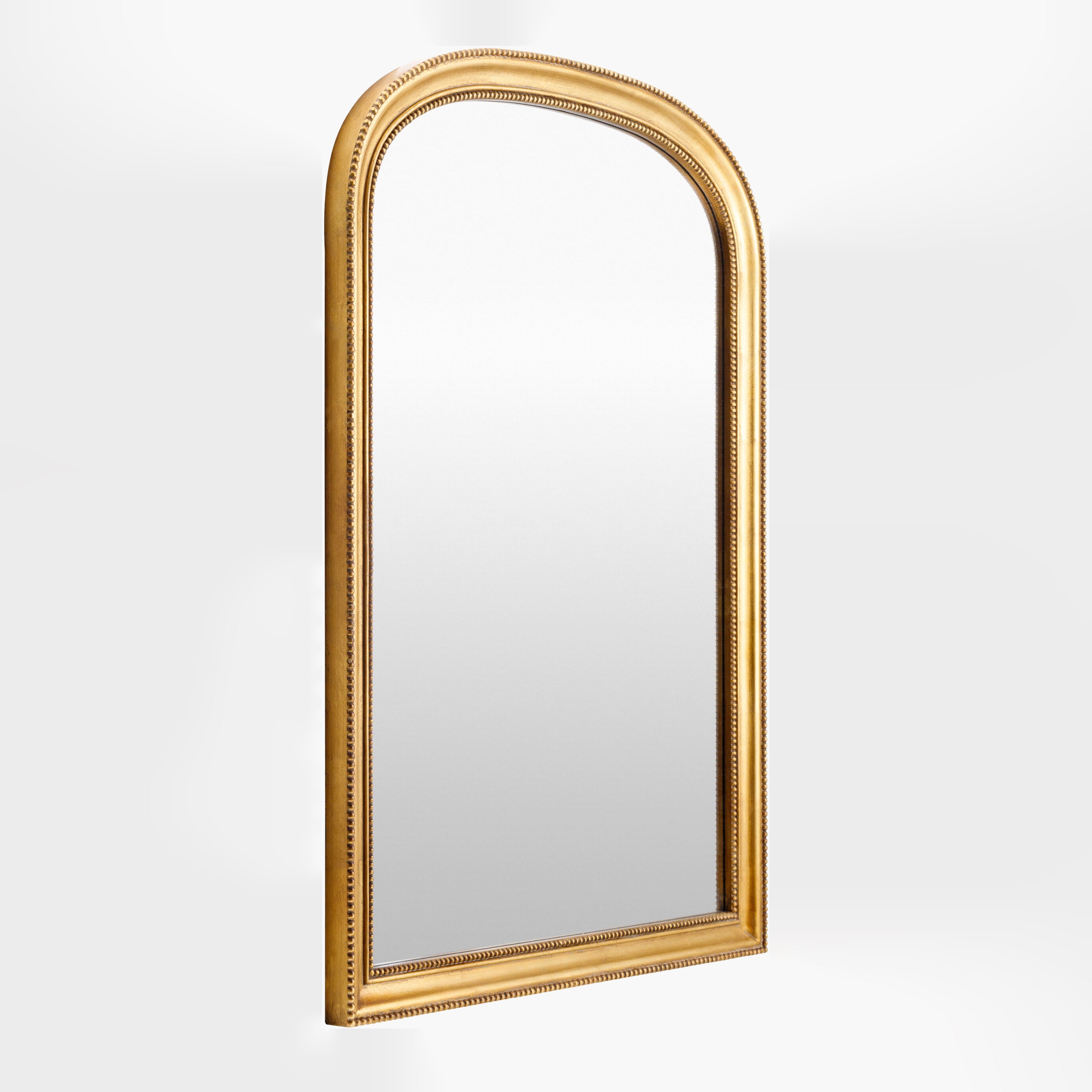 Nalanda Mantel Mirror in Antiqued Gold on a white background at Addison West