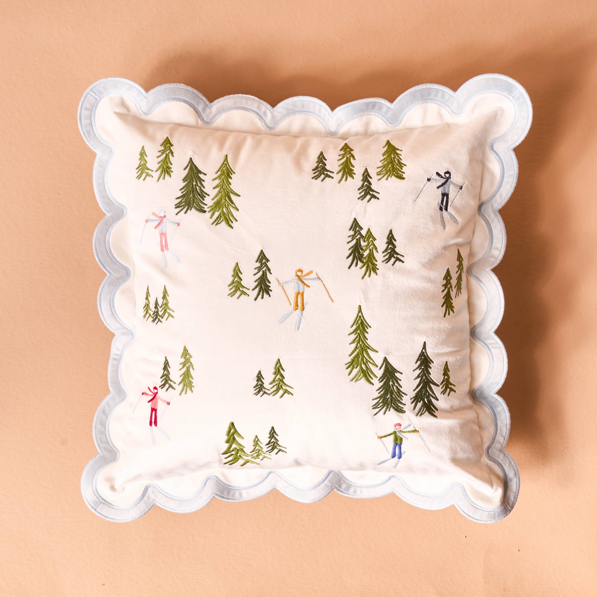 Decorative pillow with skiing and forest design on a beige background