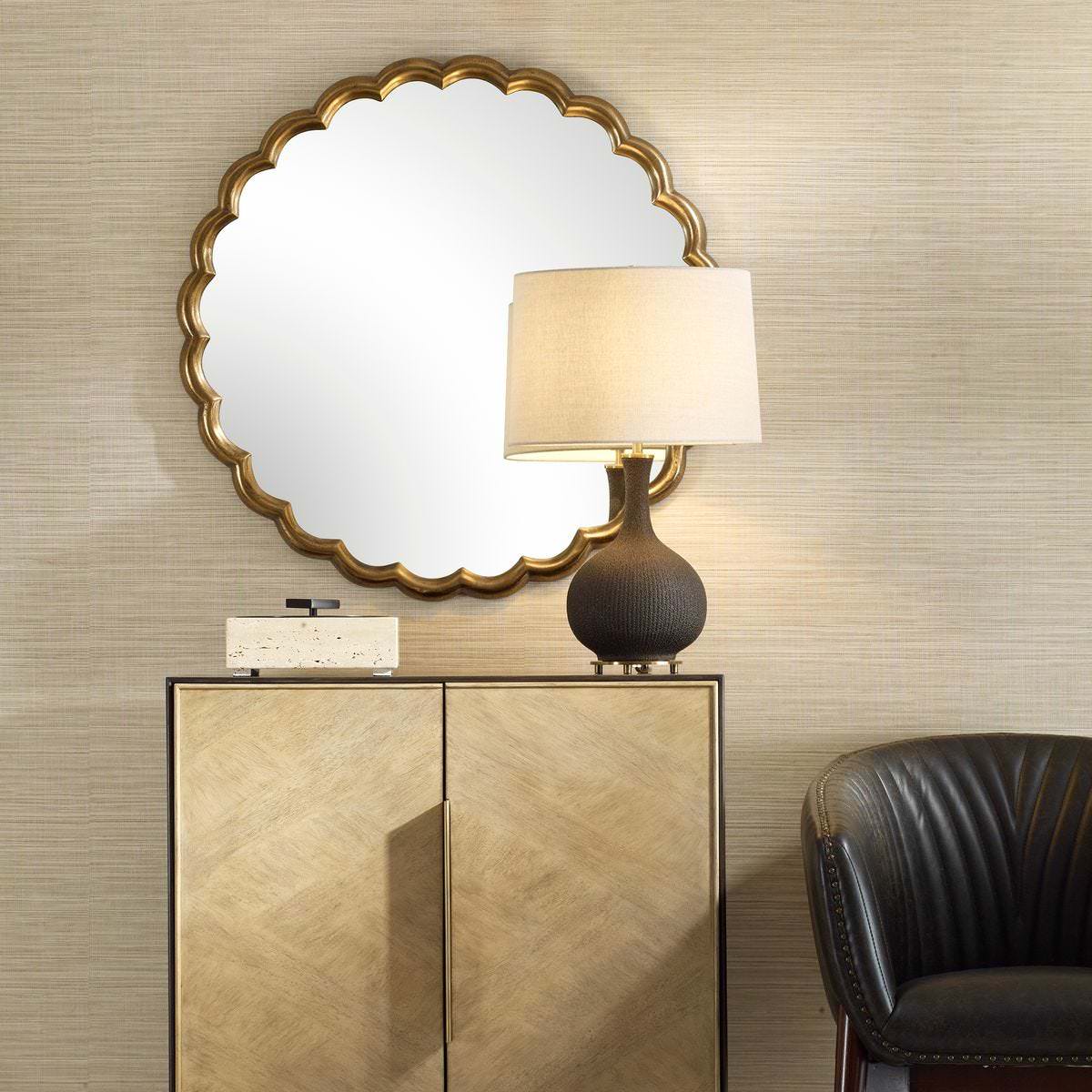 Cerelle scalloped Round Mirror on a beige wall above a table at Addison West